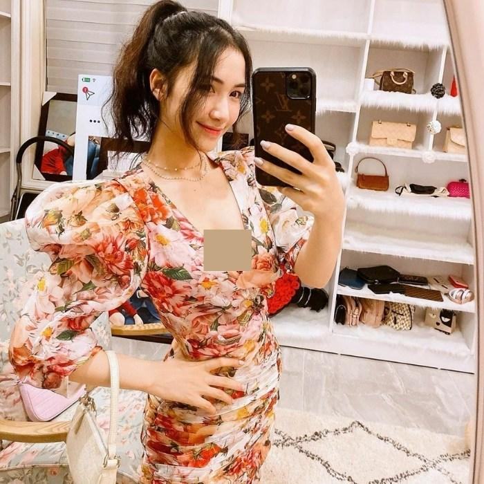 Cách tạo dáng chụp ảnh đẹp khi mặc váy hoa một tay cầm điện thoại một tay nhìn gương